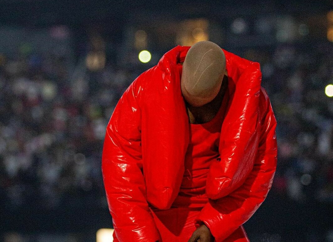 Kanye West leaving his office in a red and blue checkered jacket
